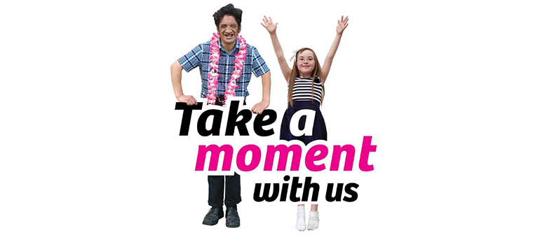 Two people cheering over the text "Take a moment with us"