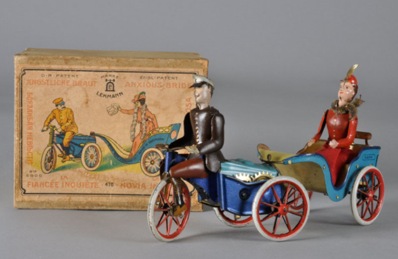 A toy of a tricycle-driven carriage containing a woman