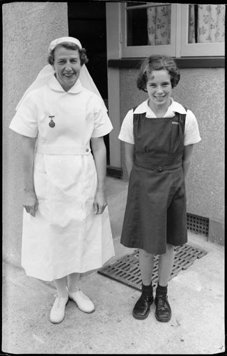 A dental nurse and a child outside a dental clinic