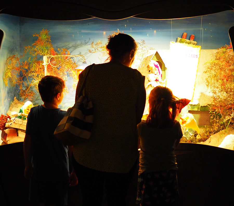 Mother and children looking at an animated display in Santa's Cave