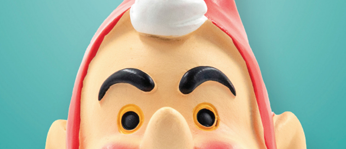 Close up of the eyes of a ceramic christmas figurine wearing a red hat