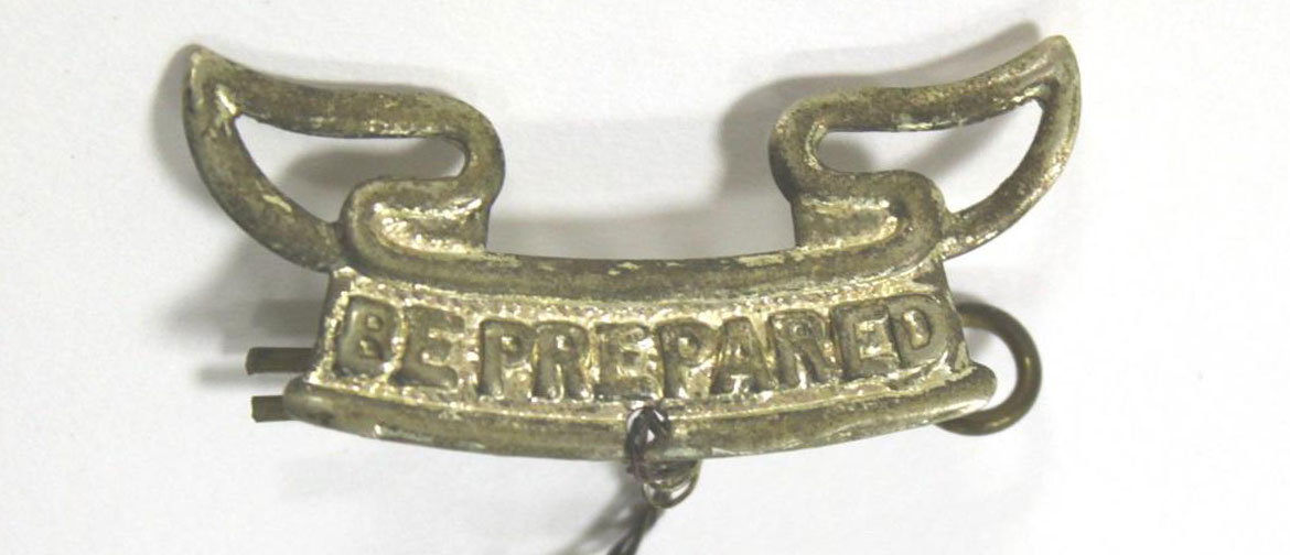A silver Scouts badge that says "be prepared"