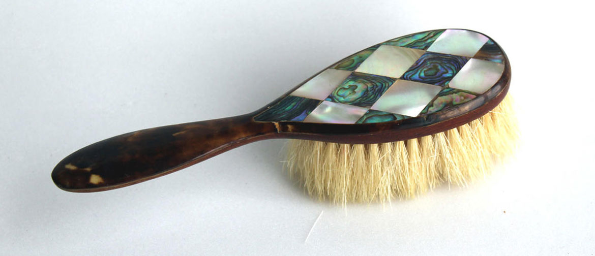 A hairbrush with mother of pearl inlay