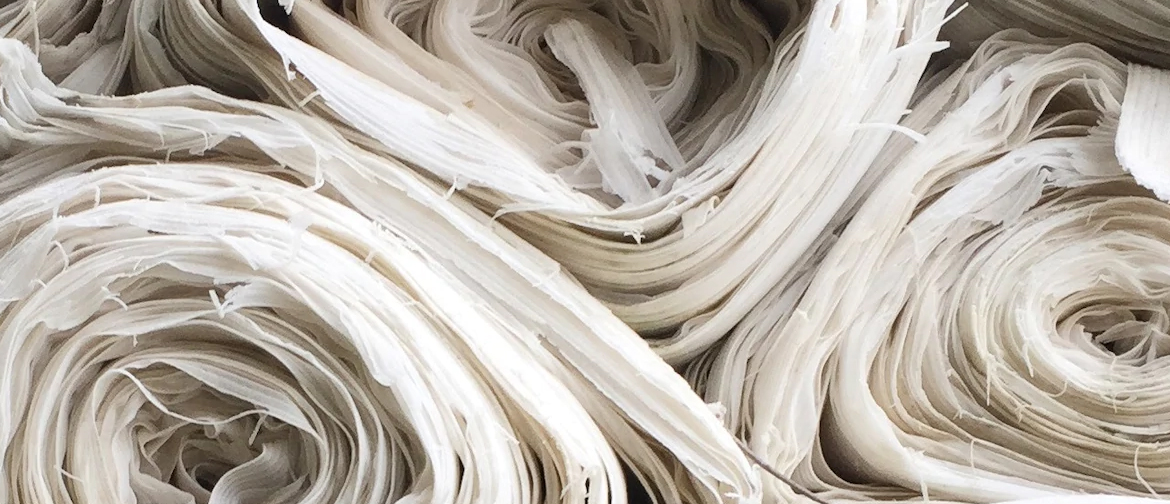 Stacked rolls of white fabric.