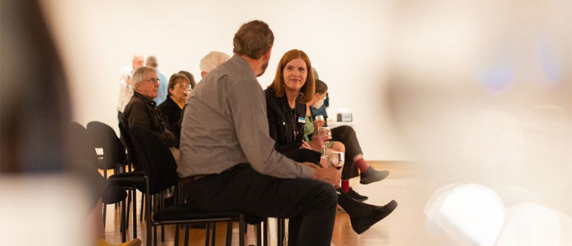 Two people in conversation at a museum event.